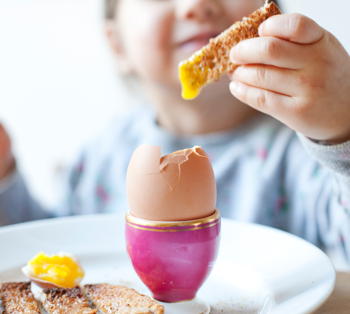 Child dipping food in egg yolk